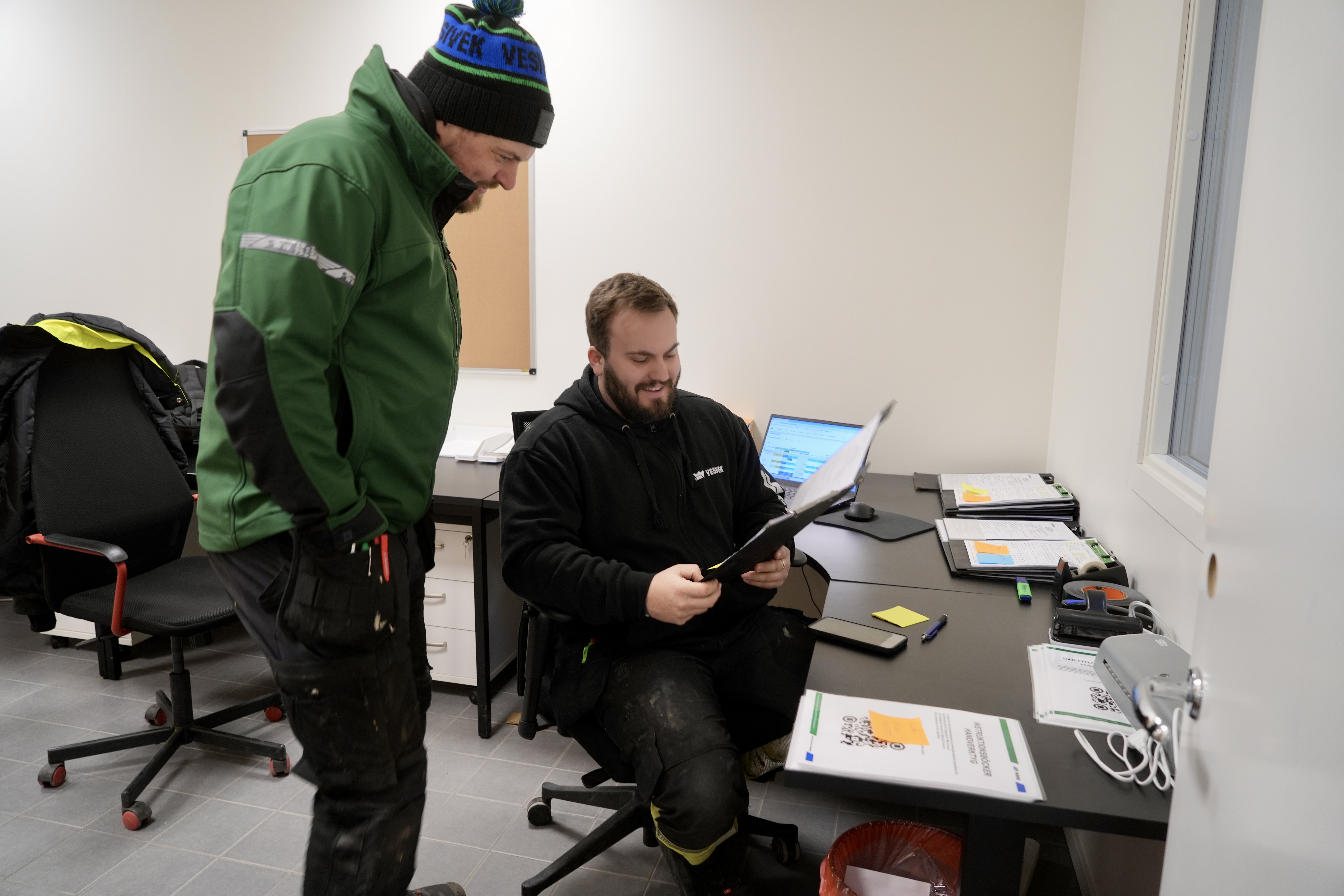 Två takexperter sitte rpå Vesiveks kontor och läser kundomdömen